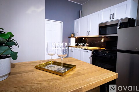 A kitchen with a wooden table and a tray with two glasses on it.