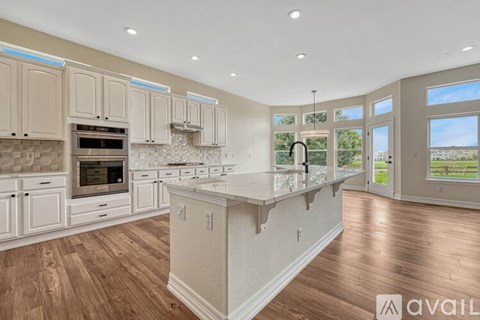 A kitchen with wooden floors and white cabinets is available for rent.