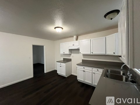 A kitchen with white cabinets and a sink.