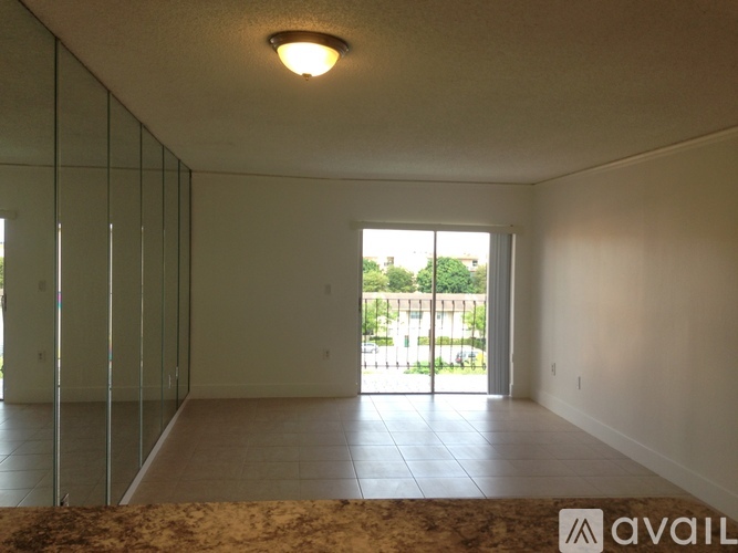 A spacious room with wood flooring and a ceiling fan.