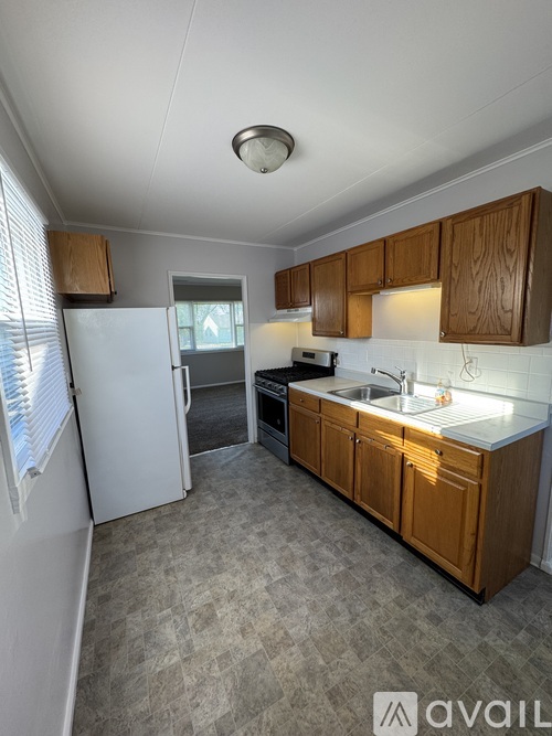 A kitchen with wooden cabinets and a white fridge.