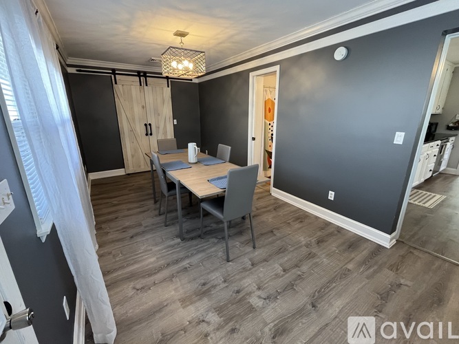 A dining room with a wooden table and chairs.