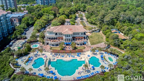 A large house with a pool in the middle of a wooded area.