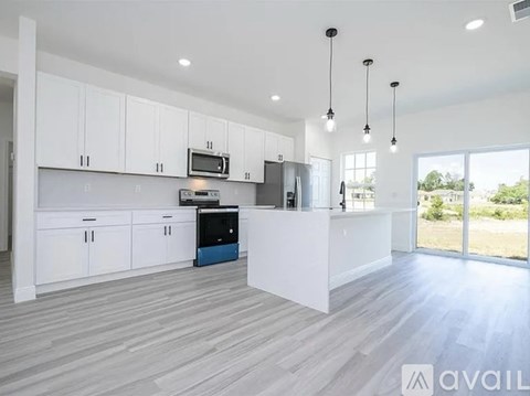 A modern kitchen with white cabinets and a large island.