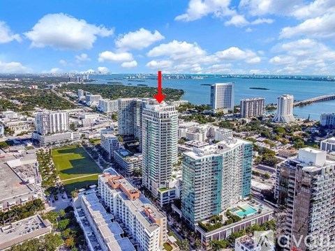 A red arrow points to a tall building in a cityscape.