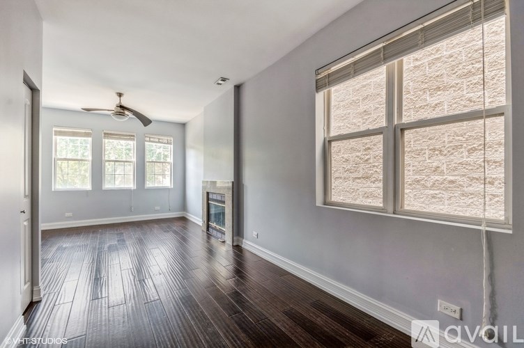 A spacious room with wood flooring and a ceiling fan.