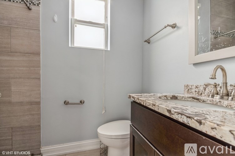 A bathroom with a toilet, sink, and a window.