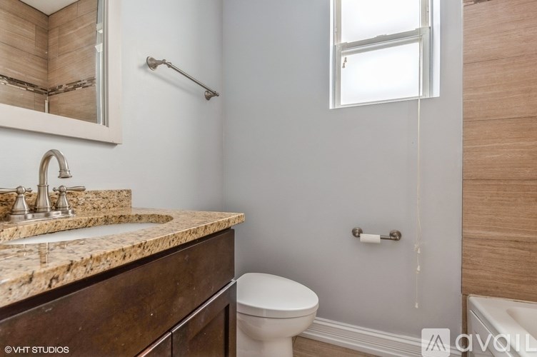 A bathroom with a marble countertop and a toilet.