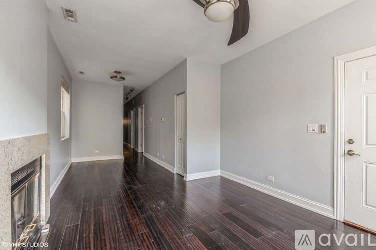 A room with a fireplace and wood flooring.