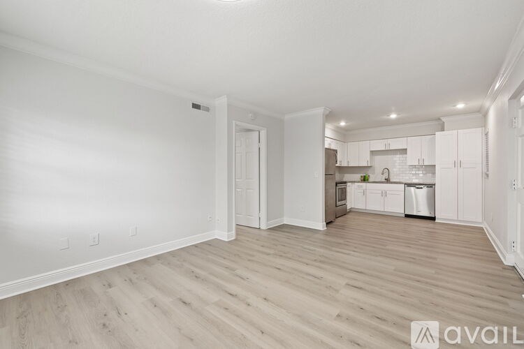 A spacious living area with a kitchen in the background.