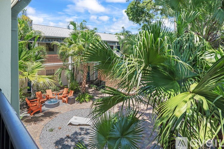 A patio with a table surrounded by palm trees.