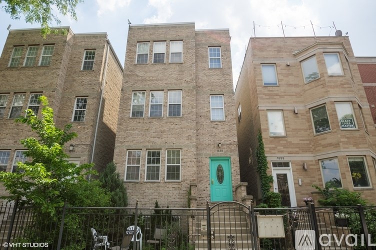 A building with a green door and a black fence in front.