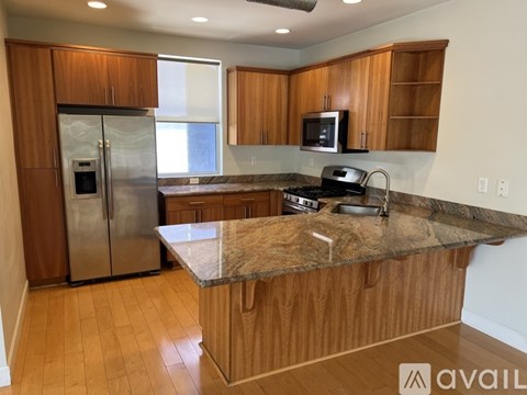 A kitchen with wooden cabinets and a granite countertop.