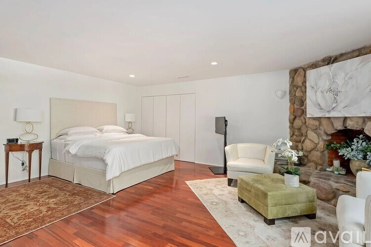 A bedroom with a large bed and a fireplace.