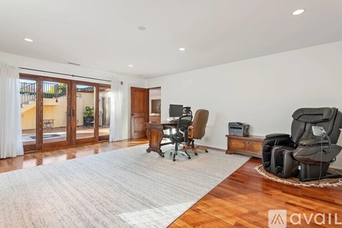 A living room with a grey sofa and a wooden floor.