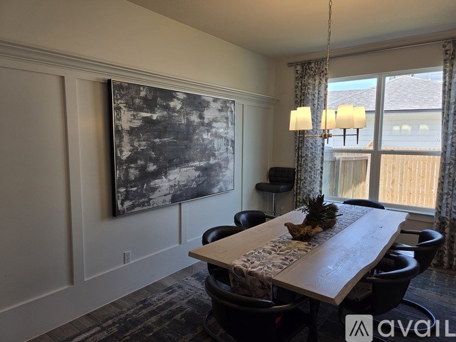 A dining room with a large painting on the wall and a wooden table with chairs.
