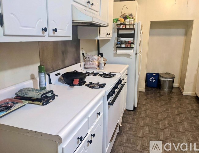 A kitchen with a white stove top and white cabinets.