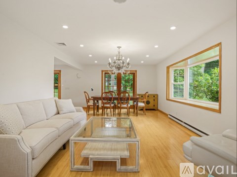 A living room with a glass coffee table and a white sofa.