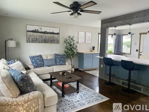 A living room with a white couch and a ceiling fan.