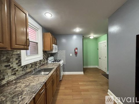 A kitchen with brown cabinets and a granite countertop.