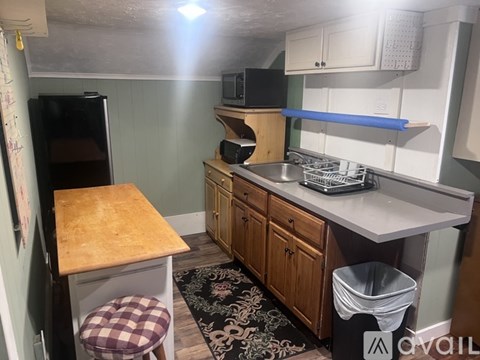 A kitchen with a wooden table and a black fridge.
