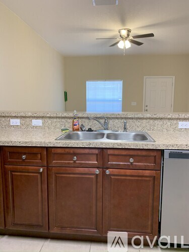 A kitchen with brown cabinets and a stainless steel dishwasher.
