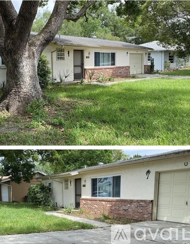 A two-story house with a garage and a tree in front.
