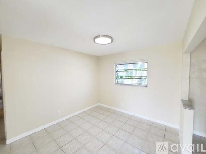 A room with a window and tiled floor.