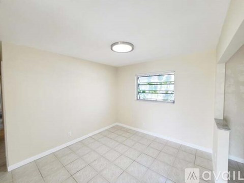 A room with a window and tiled floor.