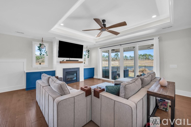 A living room with a large couch and a flat screen TV mounted on the wall.