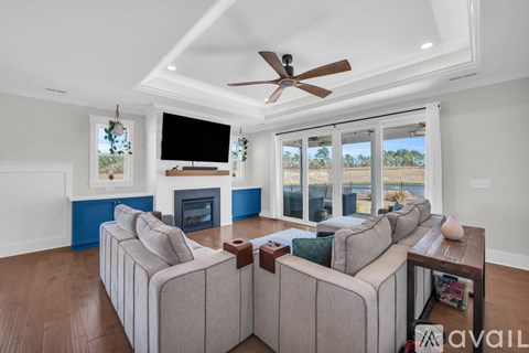 A living room with a large couch and a flat screen TV mounted on the wall.