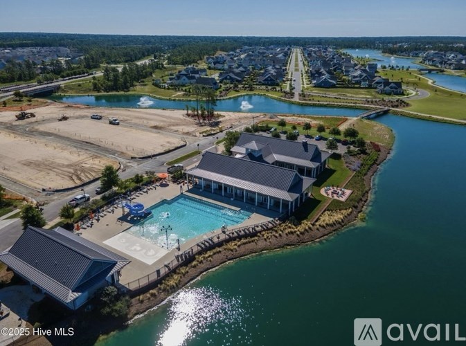A bird's eye view of a waterfront property with a swimming pool and a house.