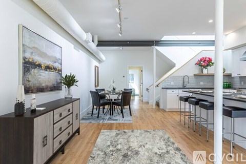 A modern kitchen with a dining table and chairs in the middle of the room.