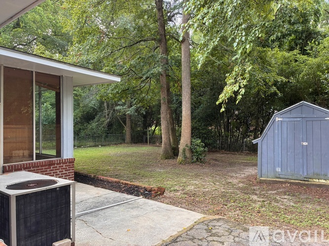 A house with a backyard and a shed.