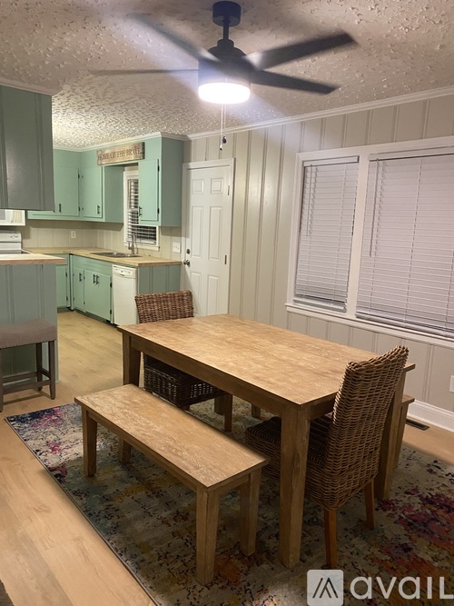 A dining room with a wooden table and chairs.