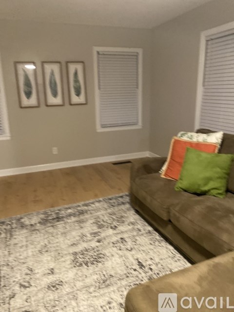 A living room with a couch and two pictures on the wall.