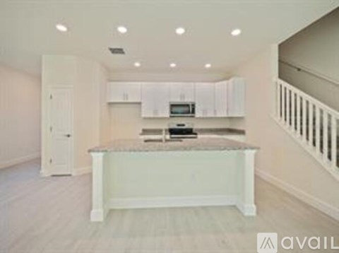 A kitchen with white cabinets and a countertop.