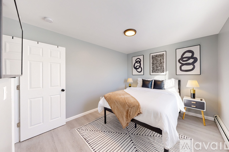 A bedroom with a bed, nightstand, and two wall art pieces.