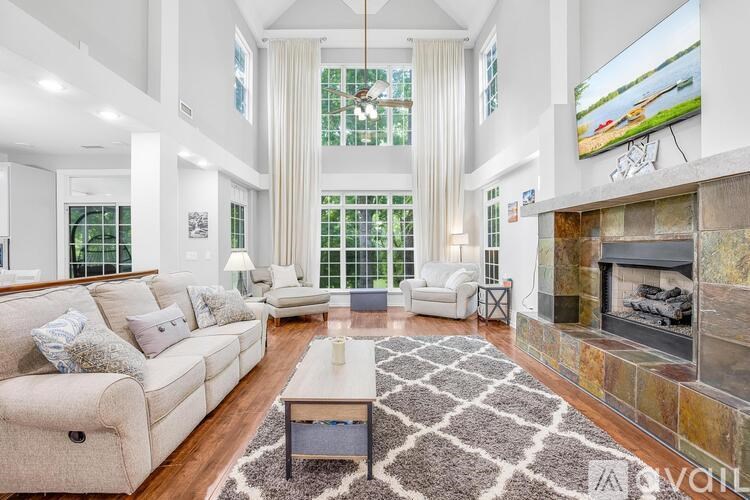 A living room with a fireplace and a large screen TV.