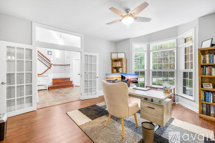 A room with a desk, chair, and bookshelf.