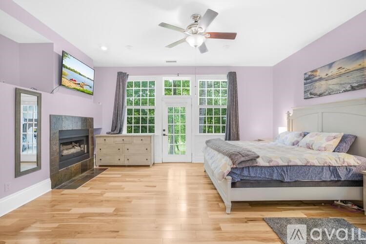 A bedroom with a bed, a fireplace, and a television.