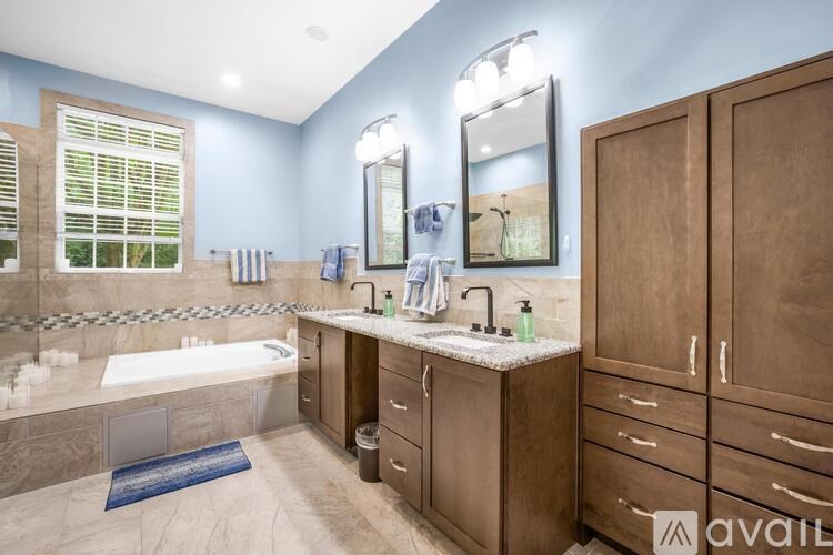 A bathroom with a tub, sink, and mirror.