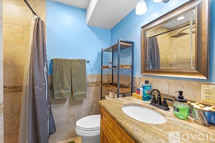 A bathroom with a toilet, sink, and shower.