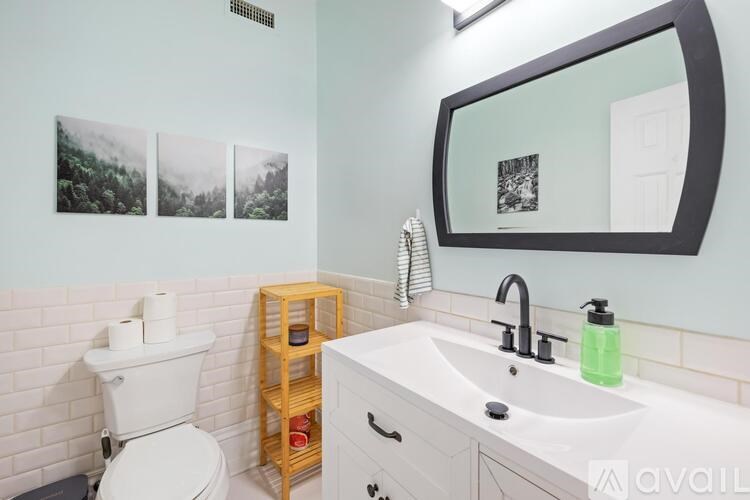 A bathroom with a toilet, sink, and a mirror.
