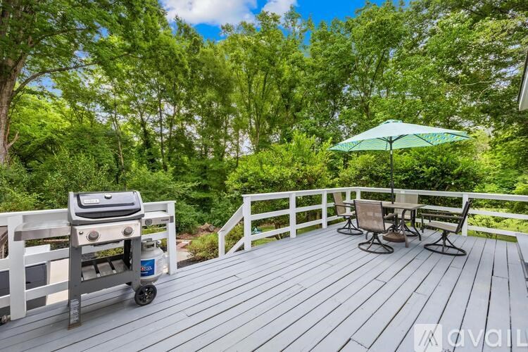 A wooden deck with a grill and chairs.