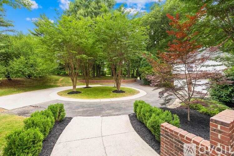 A garden with a circular walkway and a brick wall.