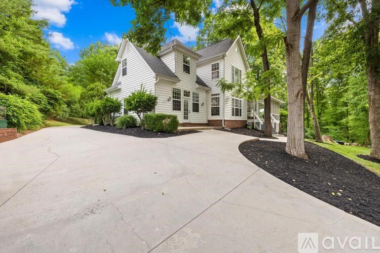 A large white house with a driveway in front.