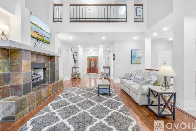 A spacious living room with a fireplace and a large rug.