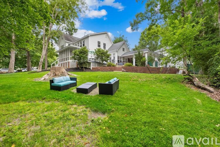 A large house with a green lawn and trees in front.