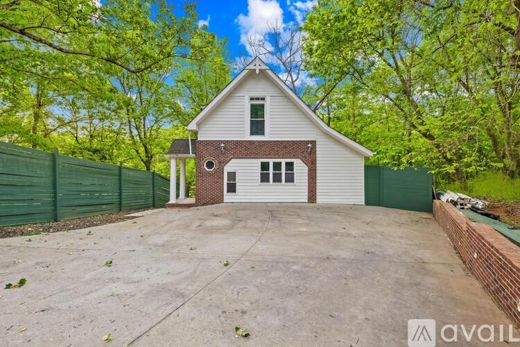 A house with a garage is surrounded by a green fence.
